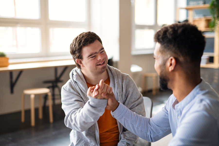 Young happy man with Down syndrome with his occupational therapist