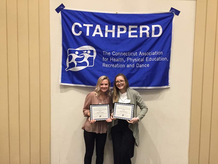 Two women holding certificates and a banner of the CTAHPERD (The Connecticut Association for Health, Physical Education, Recreation and Dance)