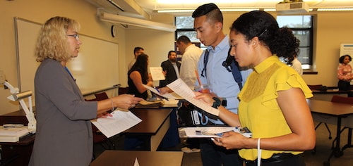 Students and professionals having a conversation at a career fair