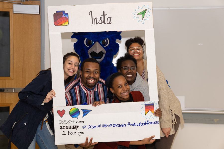 Students and UAP staff inside an Instagram picture frame cutout