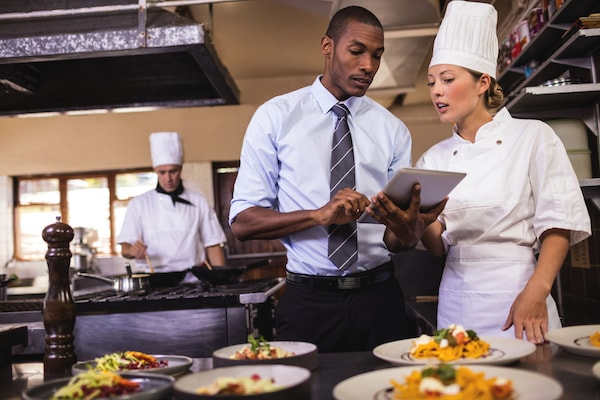 "Chefs and a manager in a kitchen setting"