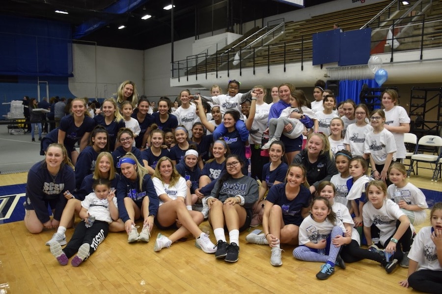 A group of female athletes gather at a gym