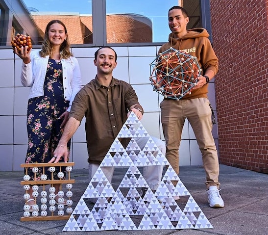 A group of three sciences students in front of an academic building