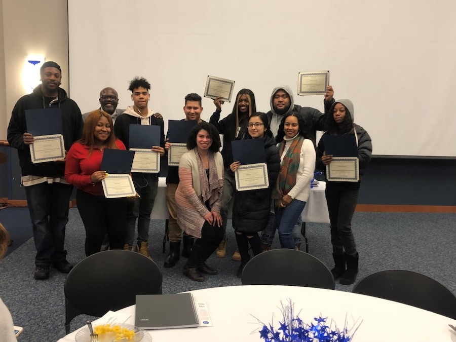 A group of students posing and holding up their diplomas