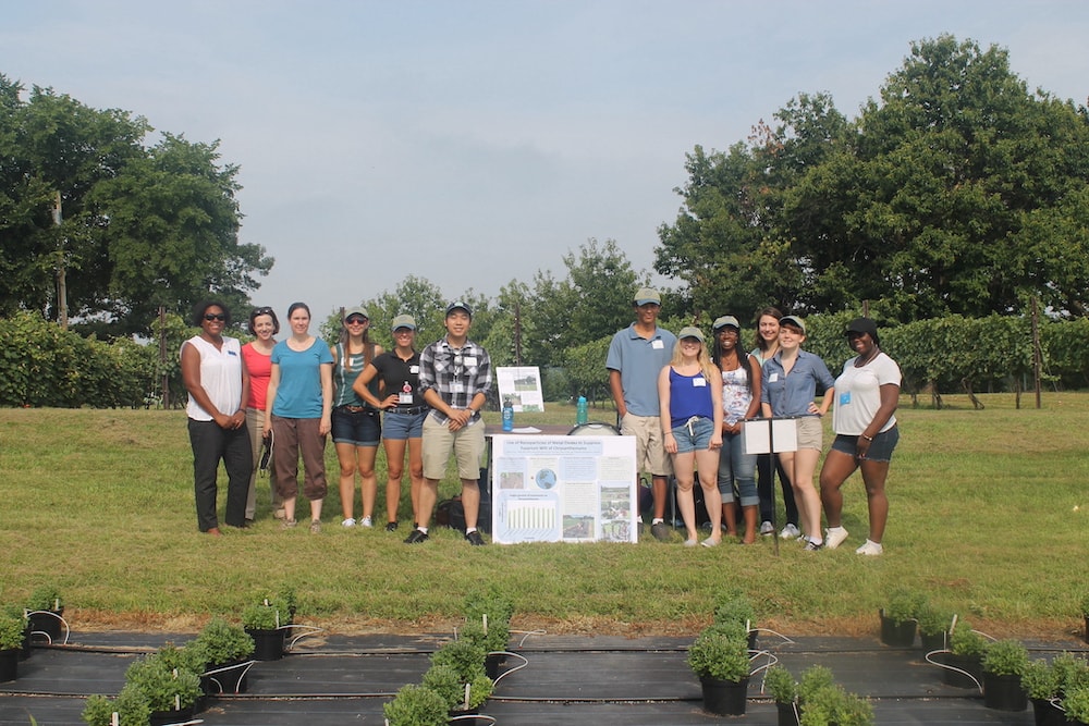 A group of students and faculty outside in an open field