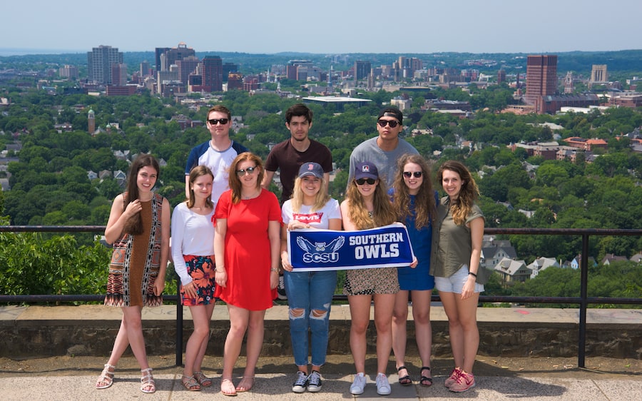 Students holding SCSU Banner with city background