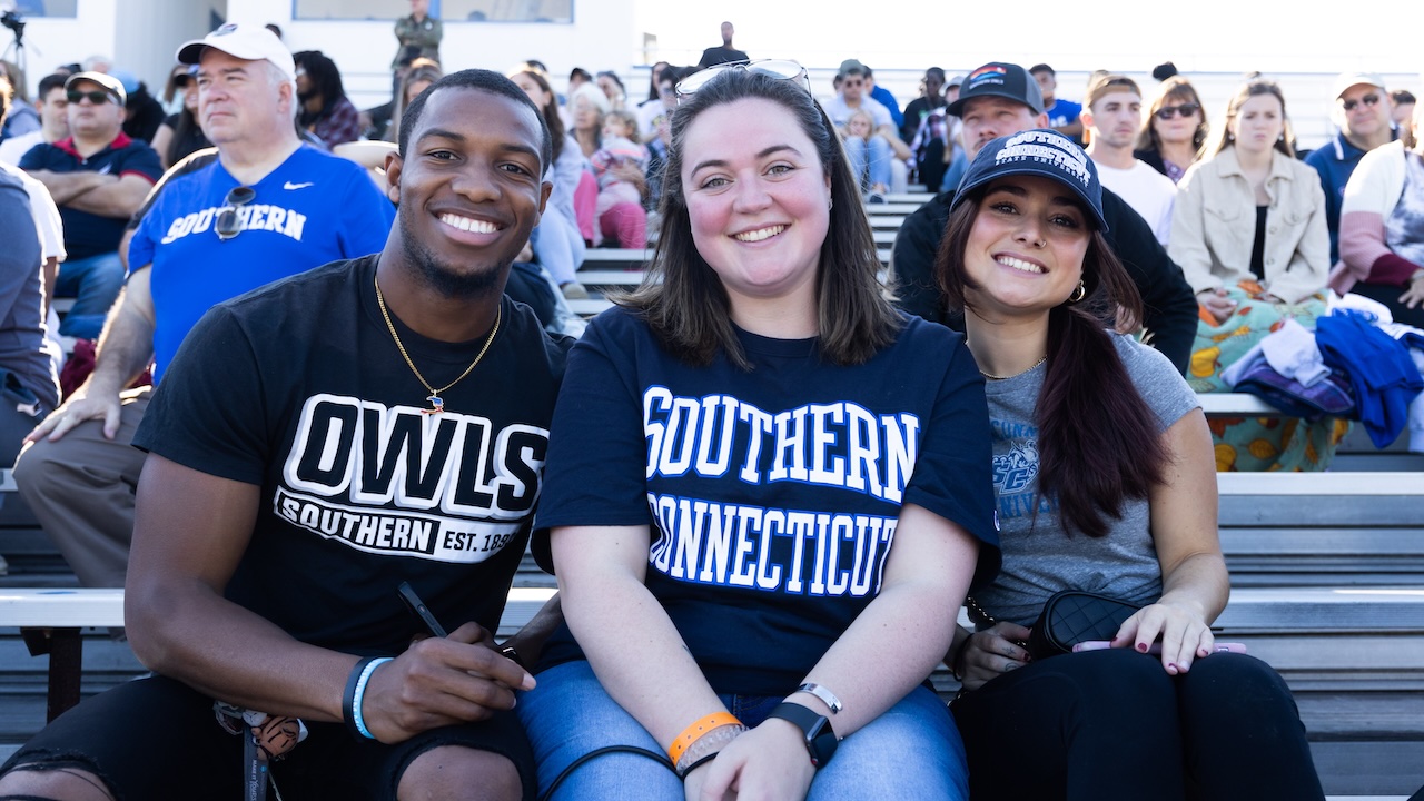 Three students watching the homecoming game