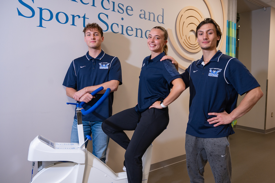 Three students, one on an exercise bike