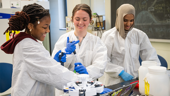 Three undergraduate students working in a laboratory