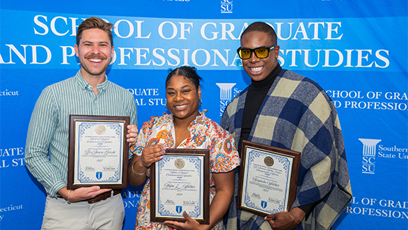 Three graduate students with their awards for best research
