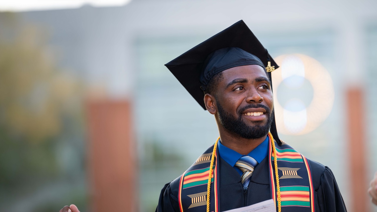 A graduate student in their cap and gown
