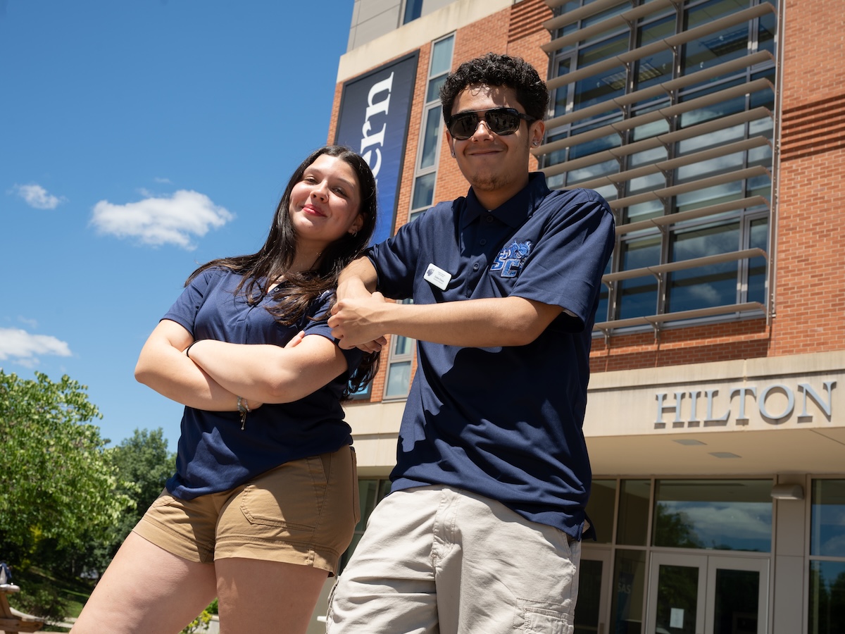 Male and female student smiling outside