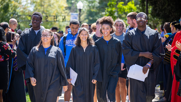 Students in academic robes walking on campus