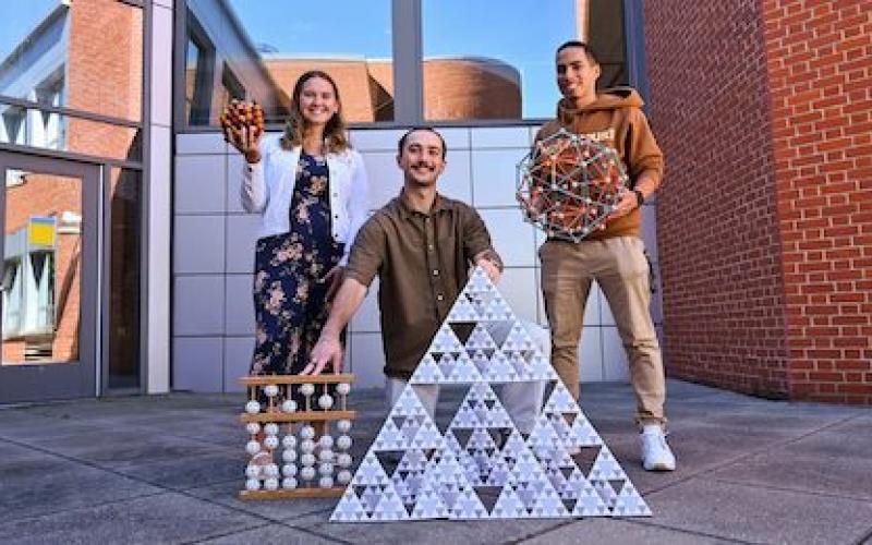 "A group of 3 students outside an academic buildining"