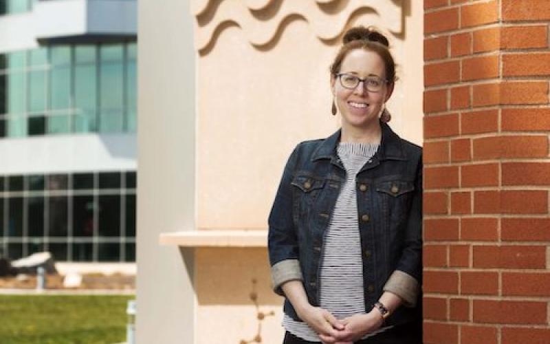 "A professor next to an academic building"