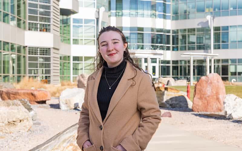 miranda holland stands in front of the Academic Science & Laboratory Building