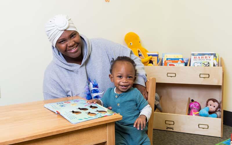 CaiLonni Haywood and her baby, Khaza, combine work and play at the family-friendly study room in Buley Library