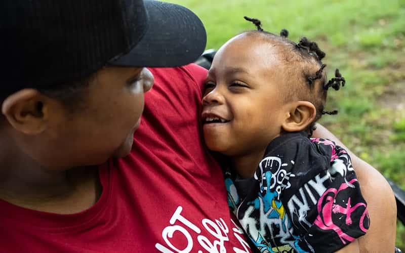 a mother holds her young child in her arms (photo Credit: Yunuen Bonaparte for The Hechinger Report)
