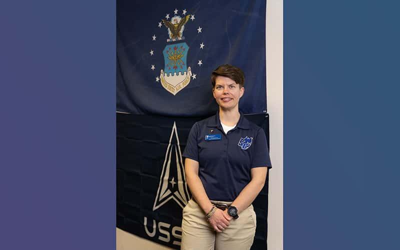 Britt Conroy stands in front of a U.S. Air Force flag