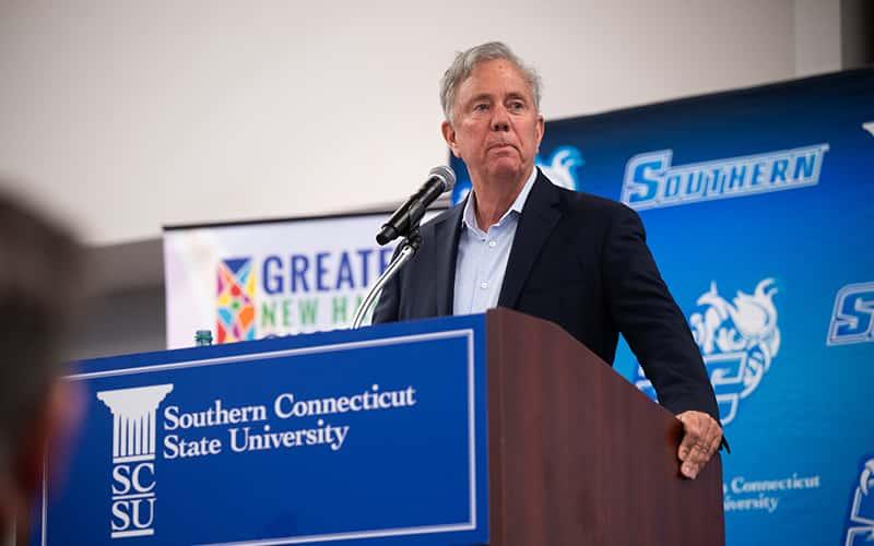 Connecticut governor Ned Lamont speaks behind a podium at SCSU