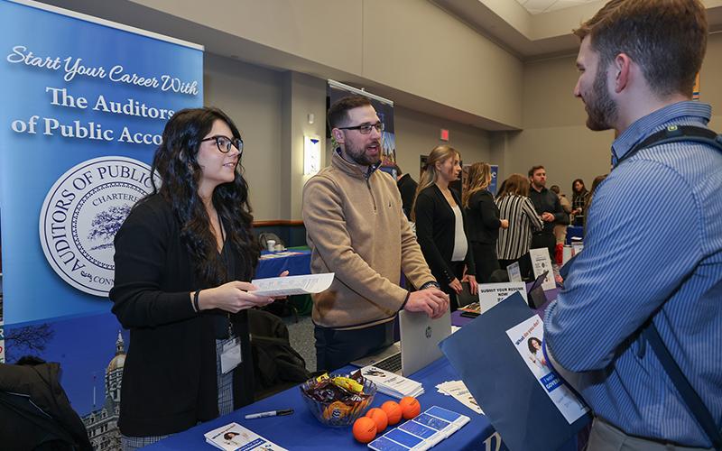 a student talks to potential employers at a campus career fair