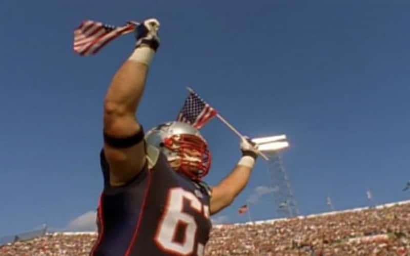 Joe Andruzzi ’19 carries American flags onto the field before the Patriots’ first game following 9/11, when his three FDNY firefighter brothers joined him as honorary captains.