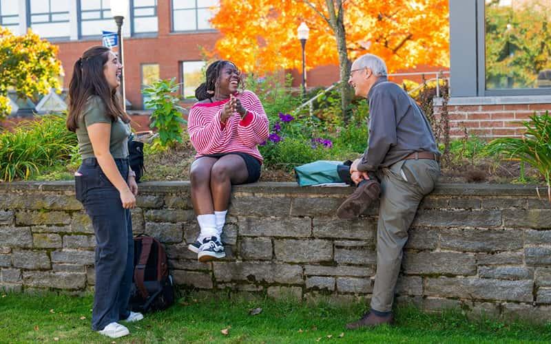 Mike Shea talks with two students outside on the SCSU campus