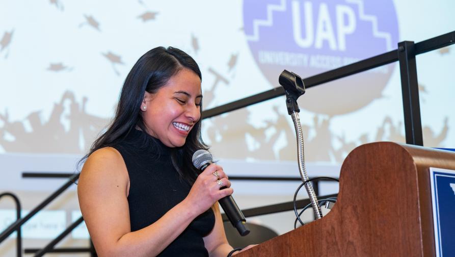 A female student gives a speech at the stand during a UAP event.