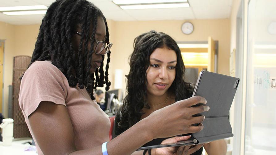 Two PASS students working together on a touchscreen device
