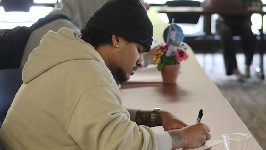 PASS student with written paper dilagently working.