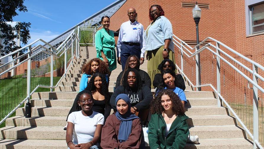 A group of PASS students sitting on steps with professors in front of Engalman Hall on Southerns University campus
