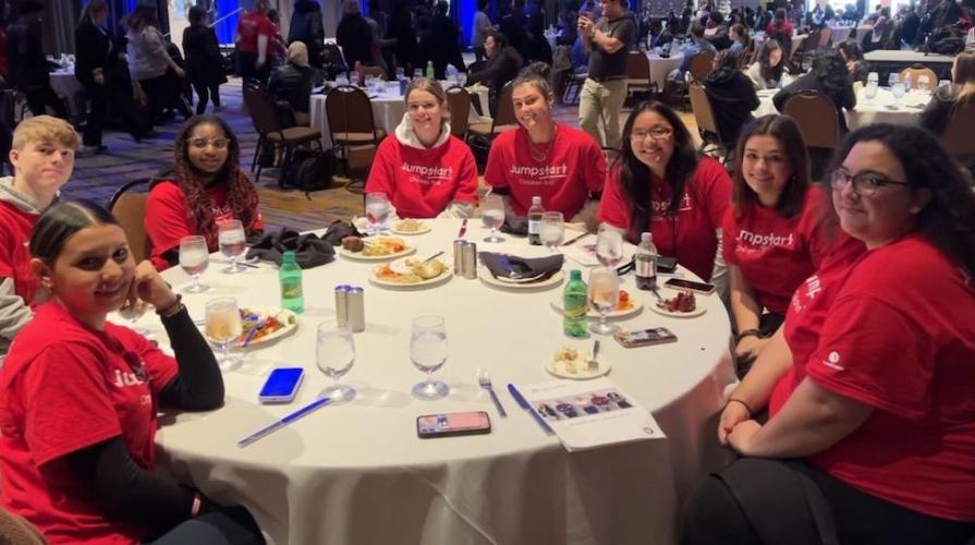 "A group of students in the Jumpstart program sitting at a round table at an event