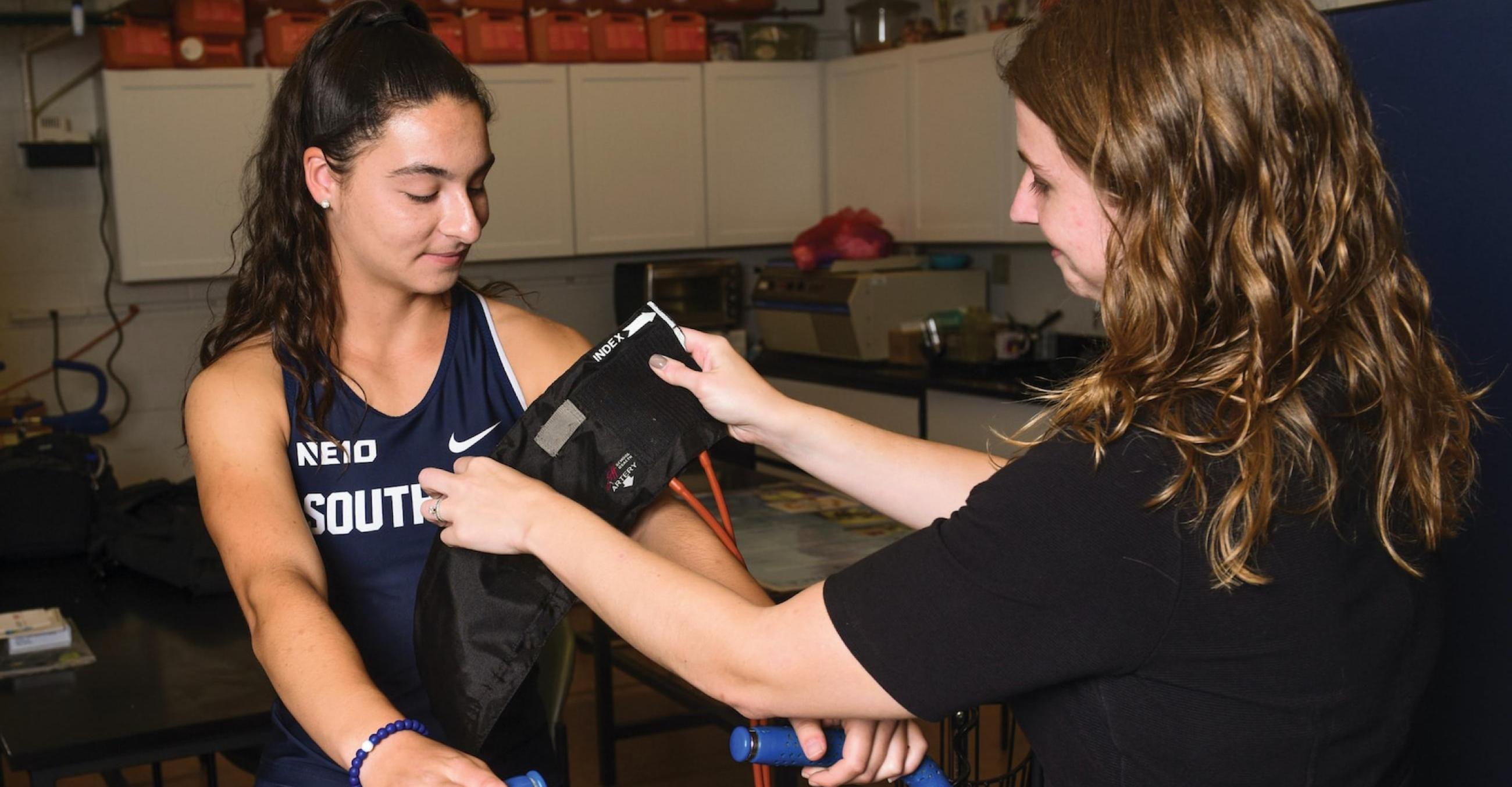 "A student taking measurements of an athlete"