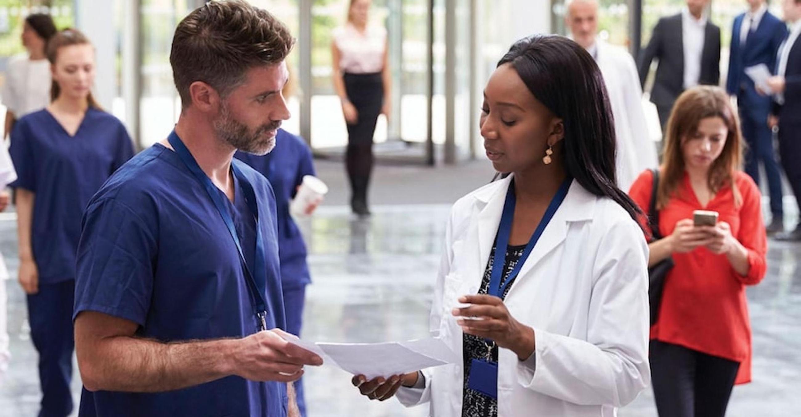 "Two healthcare workers in a hospital setting"