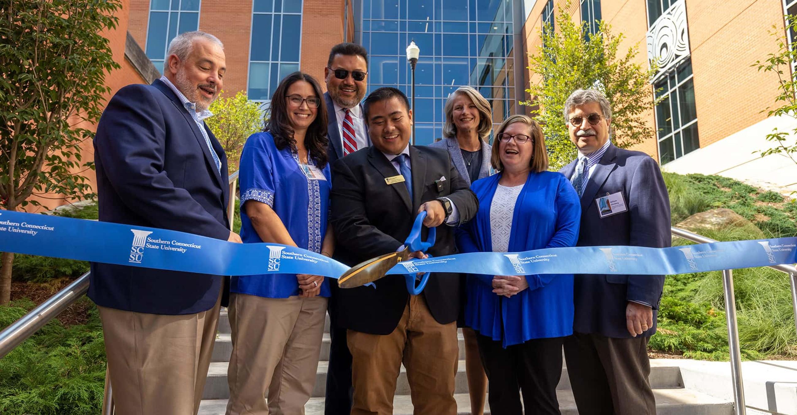 Cutting the ribbon to officially open the new building: President Joe Bertolino; Melody Lehrman, communication disorders clinic advocate; CSCU President Terrence Cheng; nursing student Dan Ybanez, '25; Dean Sandra Bulmer; Michelle Gilman, commissioner, State Department of Administrative Services; and Will Ginsberg, president and CEO, Community Foundation of Greater New Haven. 
