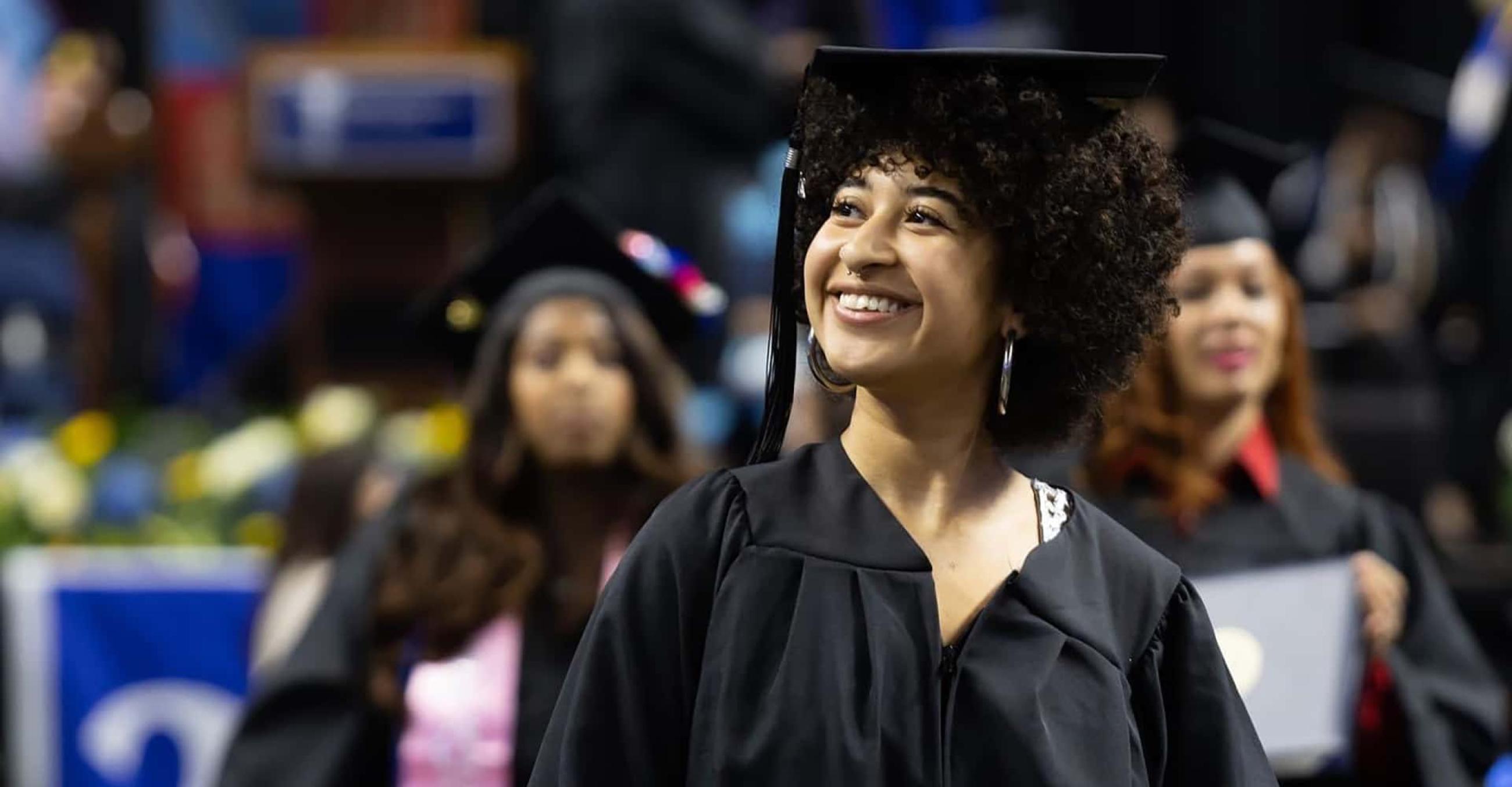 3 female students in graduation caps and gowns at undergraduate commencement