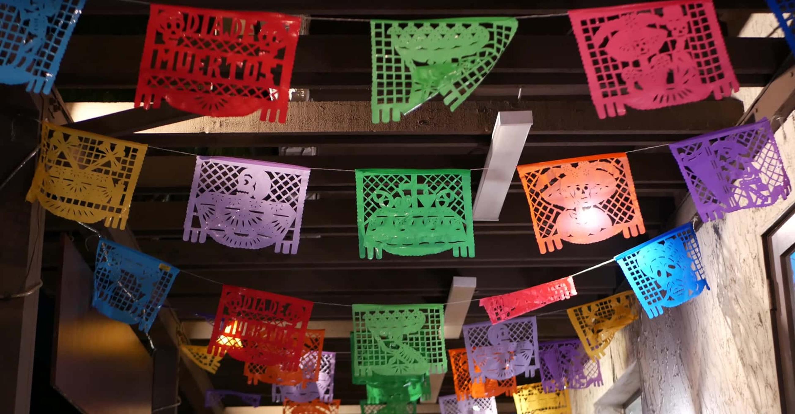 small colorful flags hang from the ceiling of an old building