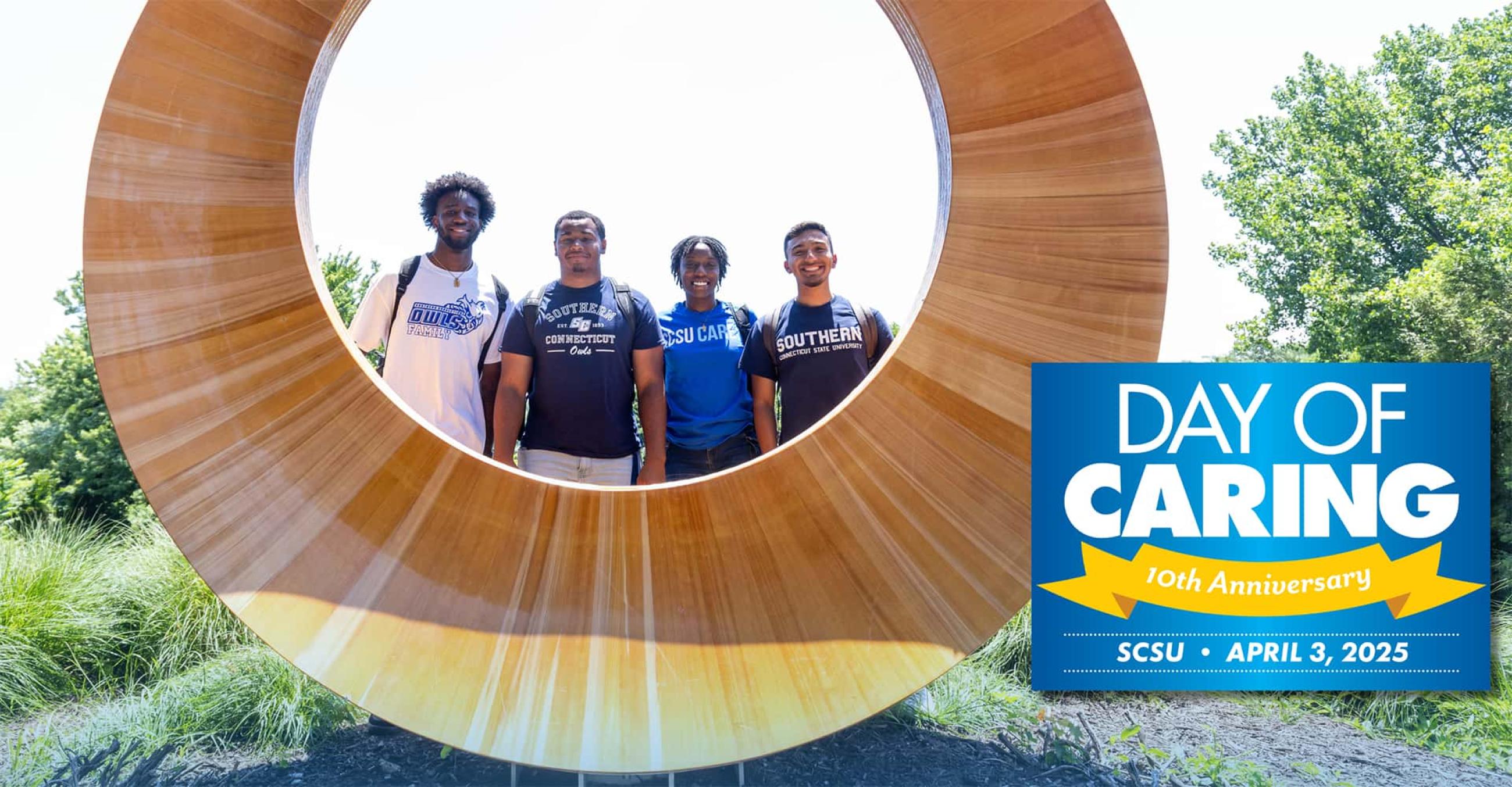 four students stand behind the Reflection Garden sculpture, with the Day of Caring logo superimposed over the image