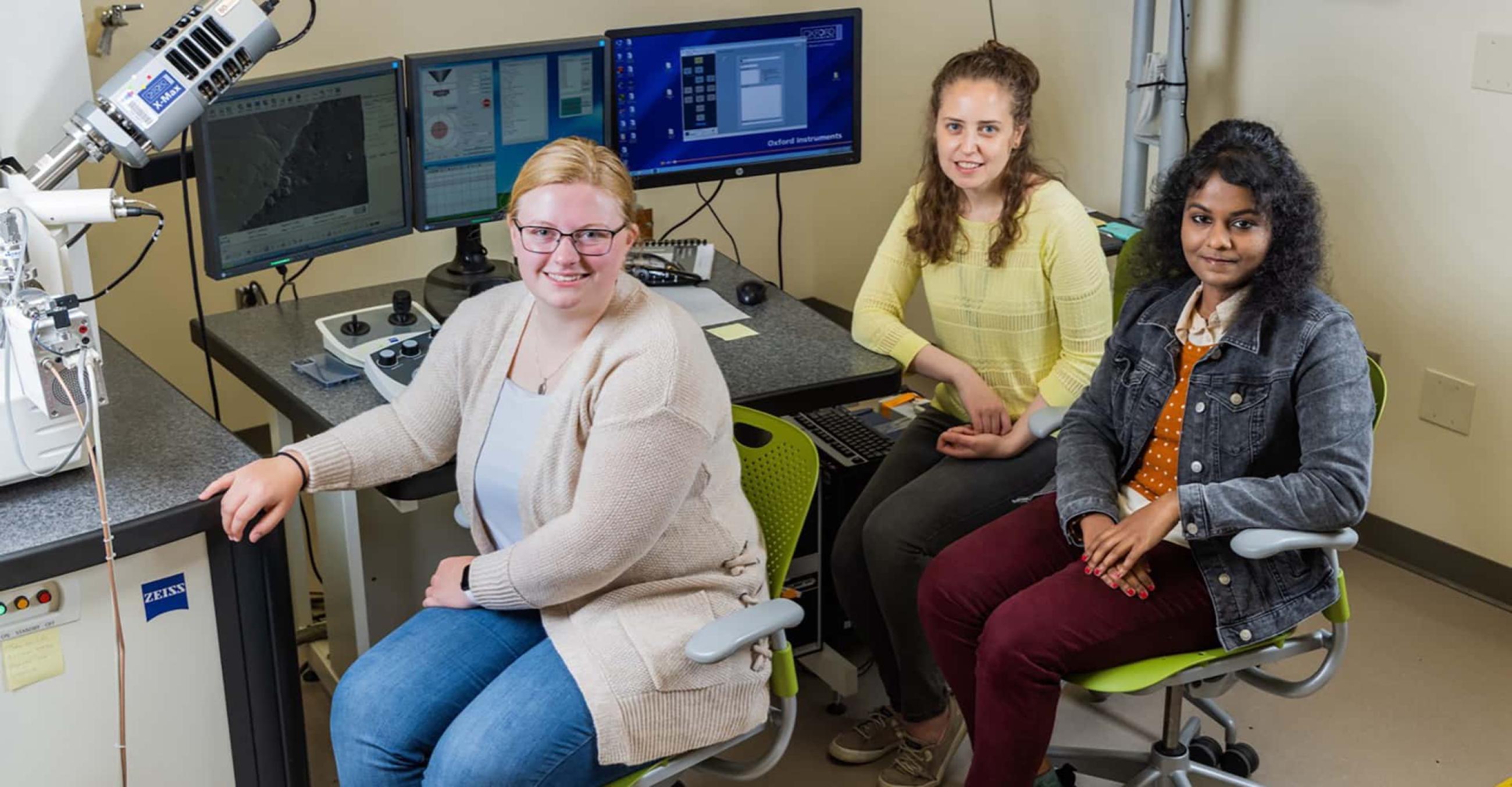 Werth Industry Academic Fellowship (IAF) alumnae Emily Davis (left), Carey Ciaburri (center), and Jennifer Moses (right) work with the scanning electron microscope (SEM).