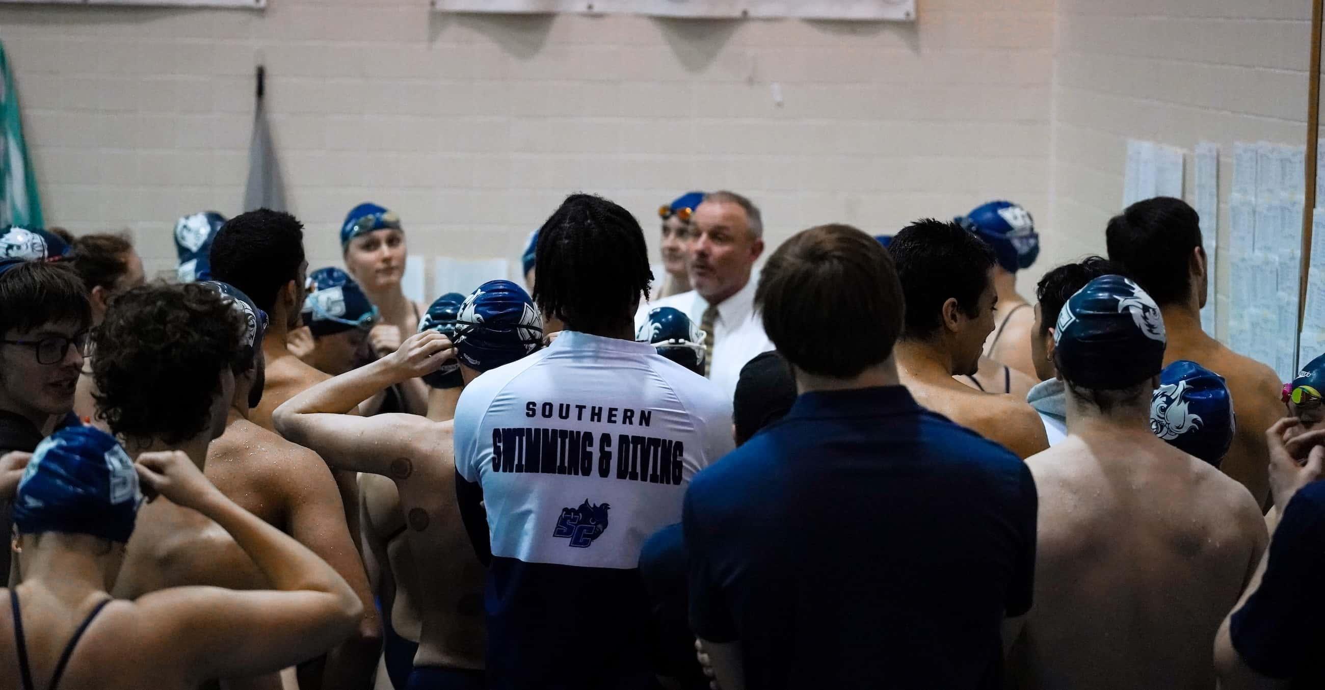 Swimming and diving coach Tim Quill surrounded by members of the SCSU swimming and diving team