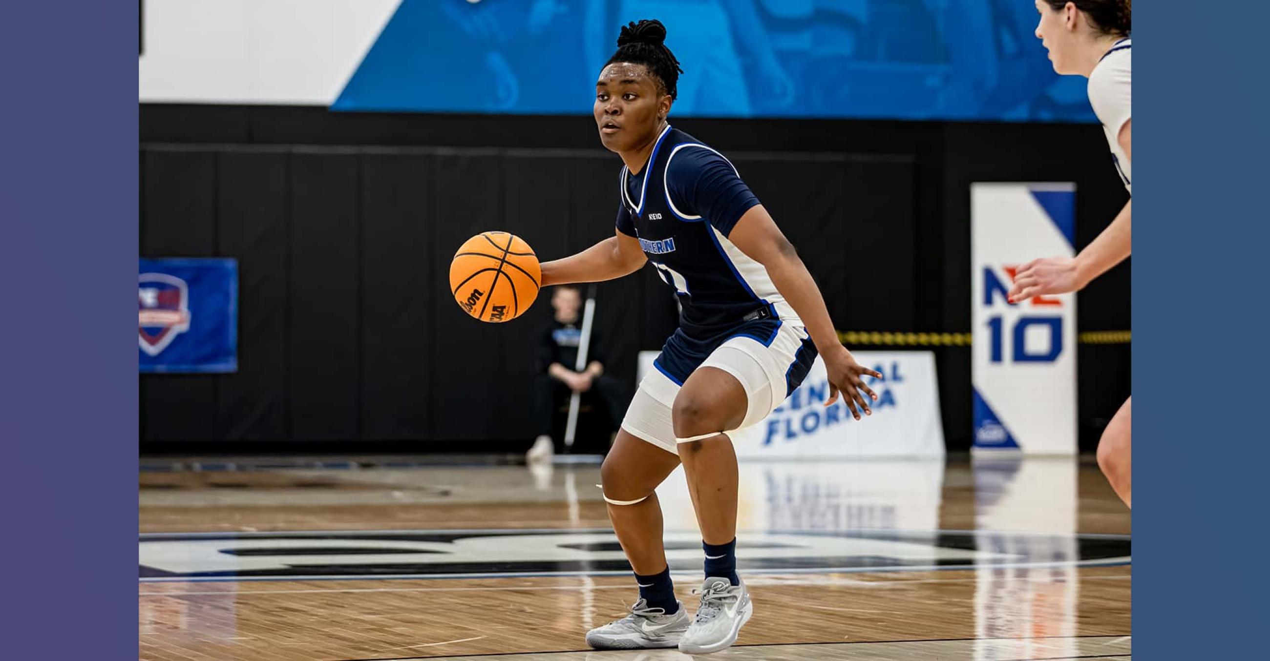 a basketball player dribbles the ball while another player on the right guards her