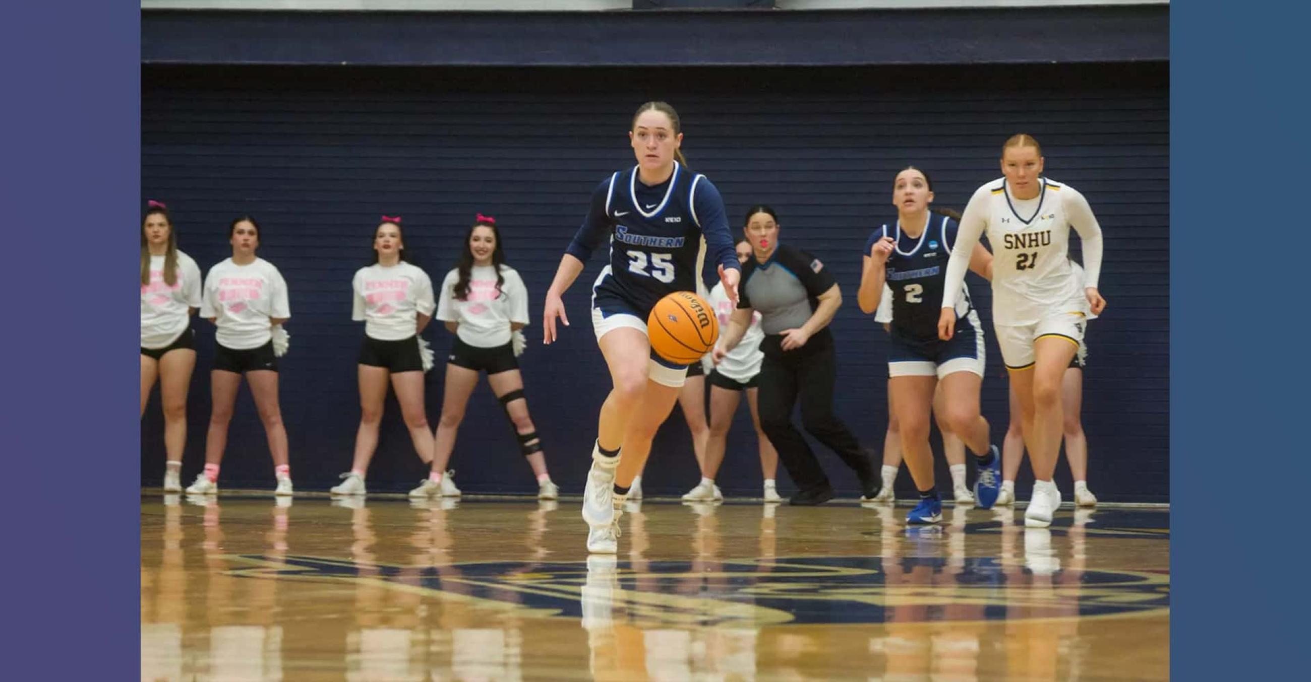 a basketball player dribbles the ball while her teammates in the background look on
