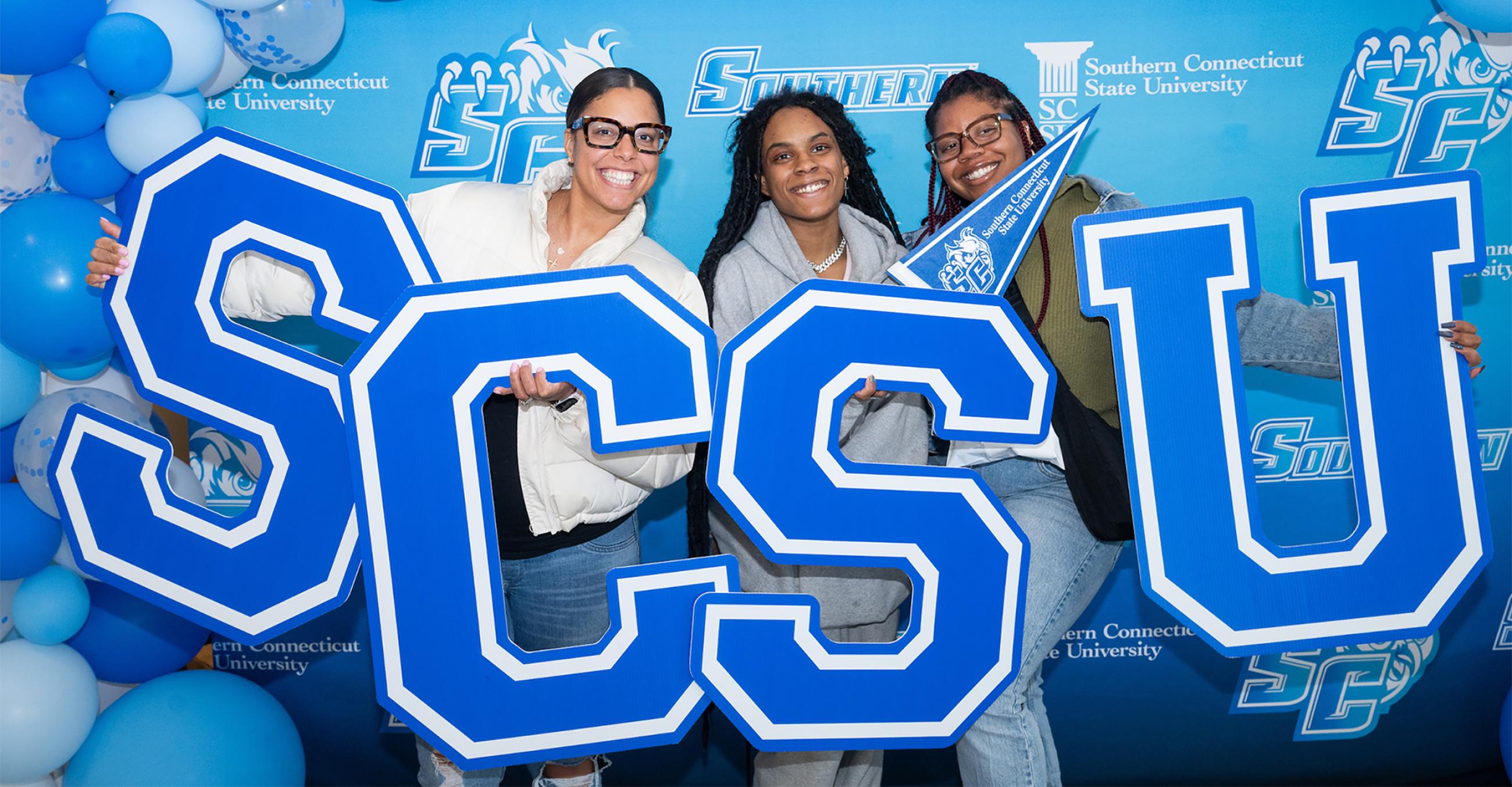 Three new students holding the letters S C S U