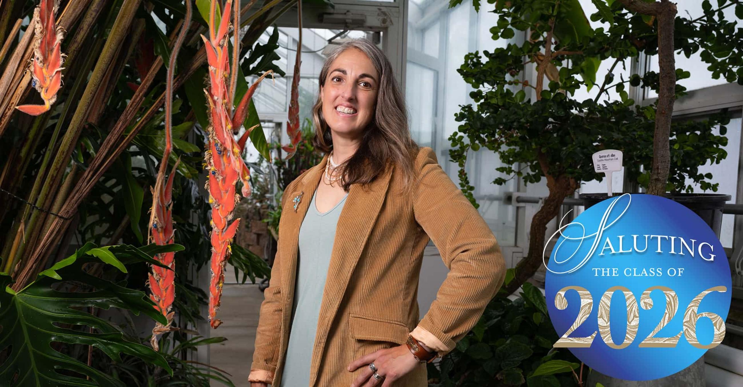 Vanessa Bunnell, class of 2026, stands in a greenhouse full of plants