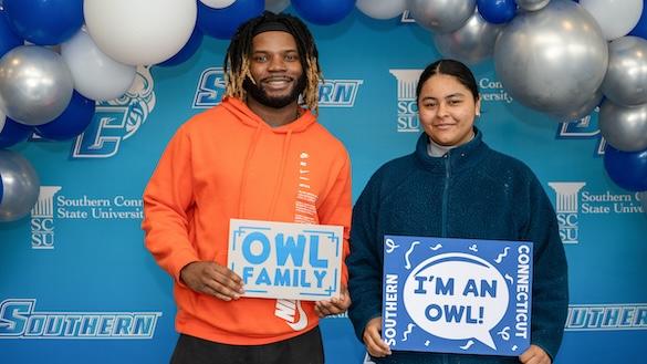 Two students holding signs declaring they're a Southern owl