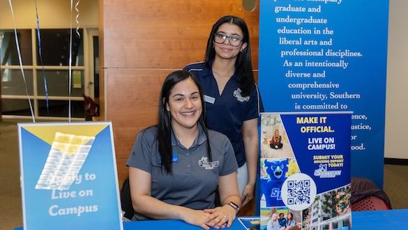 Two staff members at the Living on Campus booth