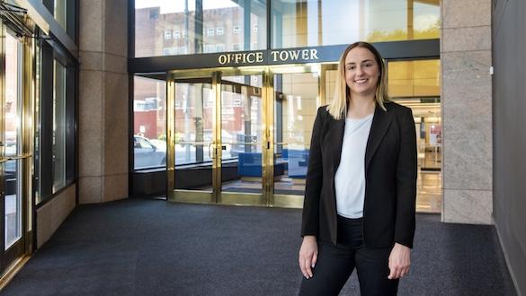 Student in a lobby with a sign that says Office Tower