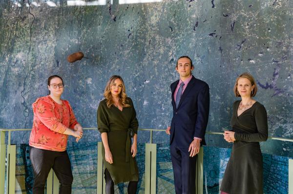 Two faculty and two students in front of a large geographic map