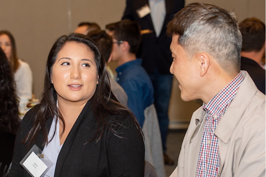 A professor and a students conversing to a background of a banquet