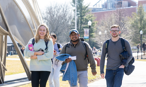 A group of three student in a university residential quad